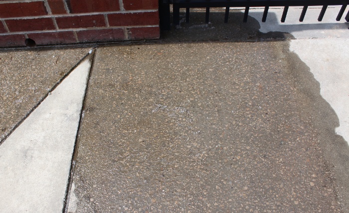 Condensation dripping out of a swimming pool dehumidifier etches the concrete sidewalk outside due to the water's low pH and chloride concentration