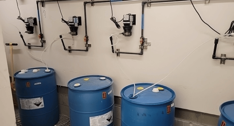 Acid feeders with 55-gallon drums of muriatic acid for a large commercial pool