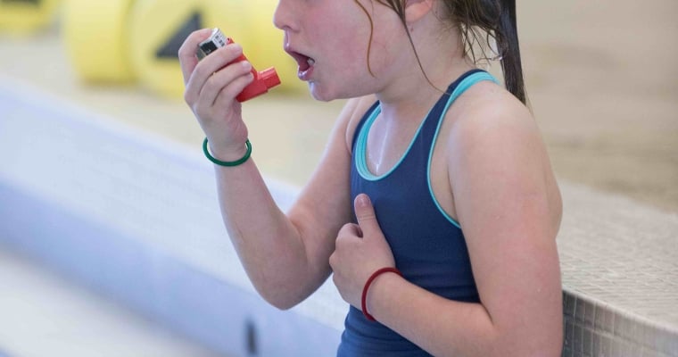 girl struggling to breathe at an indoor pool, using an inhaler, coughing after swimming. Chloramine pollution, chloramine poisoning