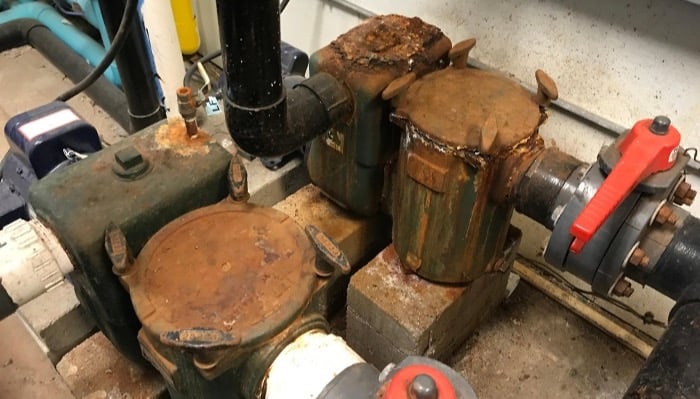 cast iron pool pumps and strainer baskets rusting in a swimming pool pump room